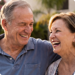 Senior couple smiling and laughing together outdoors at Fellowship Square community